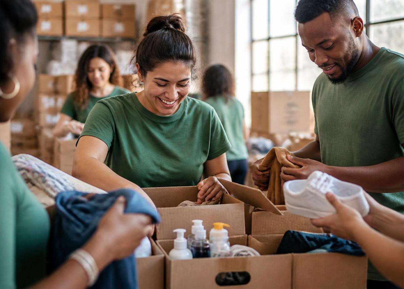 Volunteers packing donated goods into labeled shipment boxes
